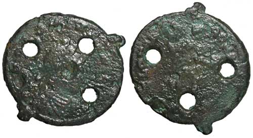 A base metal cast copy of a coin of the emperor Honorius with three holes.